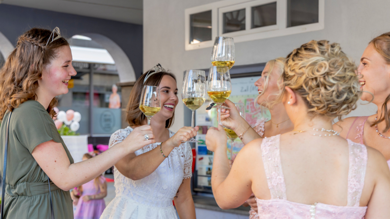 Die Zeller Weinmajestäten stoßen mit einem Glas Moselwein an.