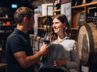 Ein junges Paar bei einer Weinprobe in einem Weinkeller im Zeller Land